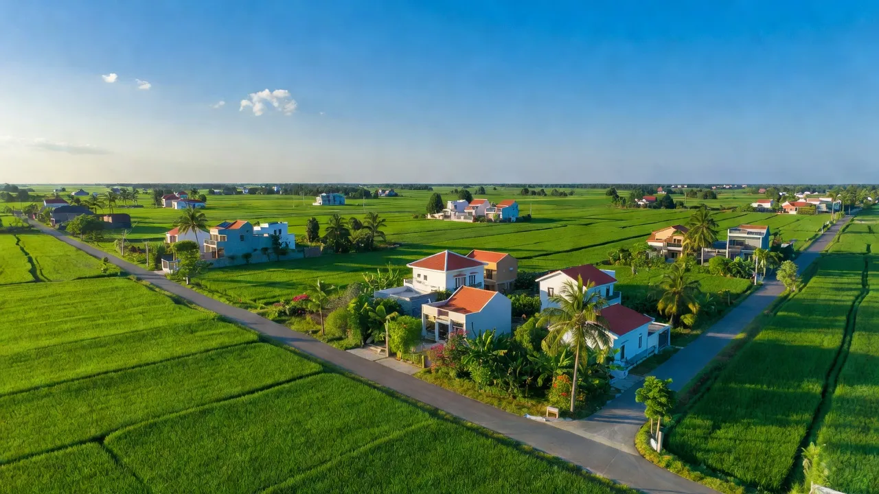Cảnh quan xã Đồng Tiến, huyện Đồng Phú, Bình Phước với cánh đồng xanh và nhà cửa hiện đại.