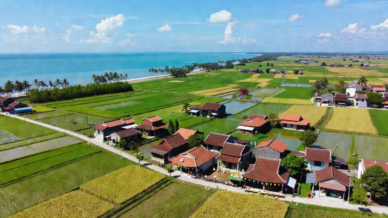 Diễn Châu, Nghệ An: Coastal landscape with rice fields, traditional houses, and clear blue sky.