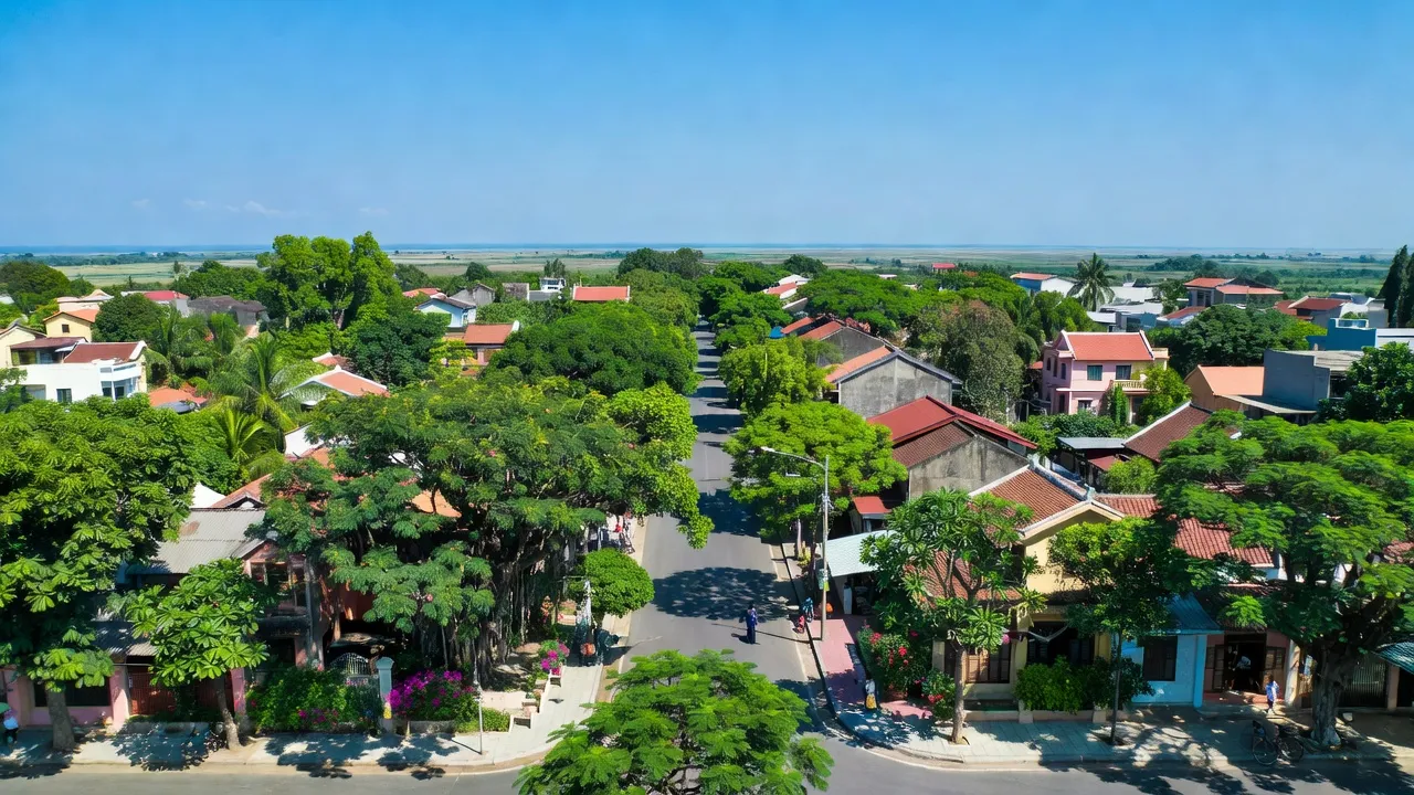 Thị trấn Diễn Thành, Nghệ An, với cảnh quan đẹp, cây xanh, và bầu trời trong, thể hiện sự yên bình.
