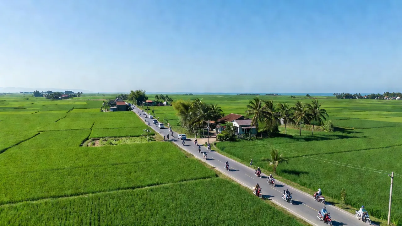 Cảnh quan xã Liên Trạch, Bố Trạch, Quảng Bình với cánh đồng xanh và đường giao thông nhộn nhịp.