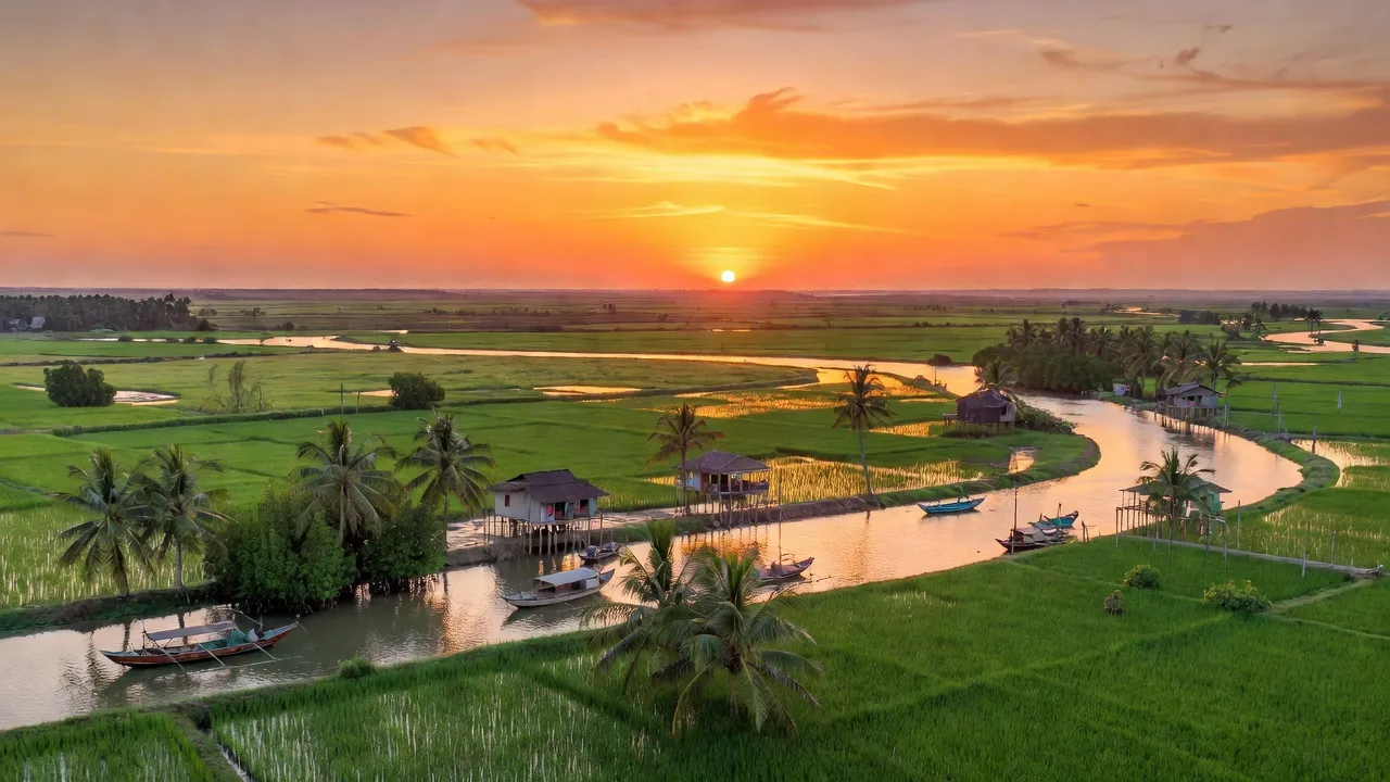 Khung cảnh ven biển huyện Trần Đề, tỉnh Sóc Trăng với đất đai xanh tươi và hoàng hôn rực rỡ.